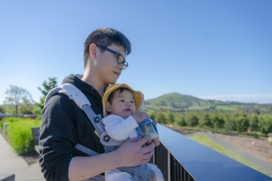 捧奶瓶的婴儿与爸爸在酒店观景台上