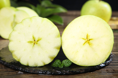 黑石底上放着切面的青森王林苹果