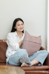 年轻女性坐在沙发上看镜头微笑