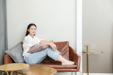 年轻女性坐在沙发上看镜头微笑