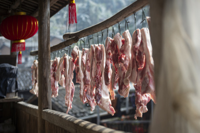 农村屋檐下悬挂的准备加工腊肉的肉块