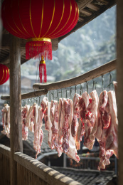农村屋檐下悬挂的准备加工腊肉的肉块