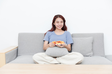 活力女性坐在客厅沙发吃水果