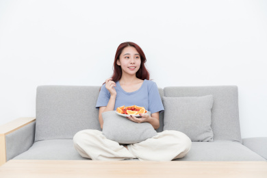 活力女性坐在客厅沙发吃水果