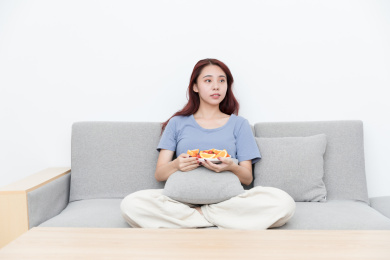 活力女性坐在客厅沙发吃水果