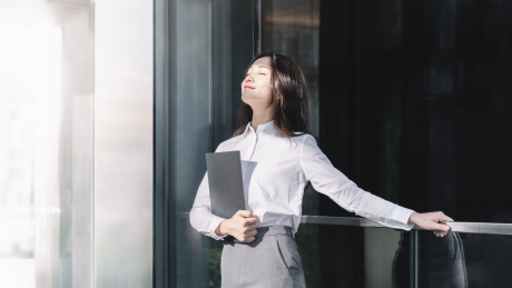 亚洲商务女性抬头闭眼享受阳光
