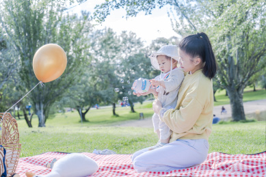 湖畔草坪上的幸福妈妈与开心宝宝