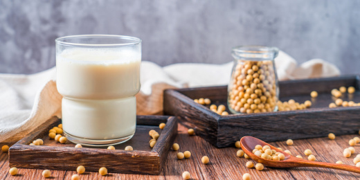 洒在桌面上的许多大豆和一杯豆浆