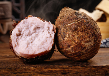 木底上放着一个完整的荔浦芋头和半边紫藤芋