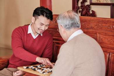 春节父子在中式客厅里下围棋