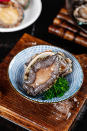 木底上碗里放着一个鲜冻大鲍鱼