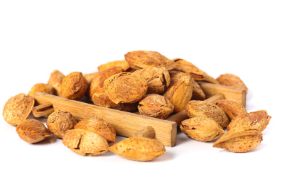 白底上放着一堆巴旦木和木垫上放着扁桃仁