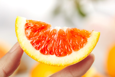 手上拿着一块中华红血橙