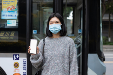 戴口罩女孩拿着白色屏幕的手机