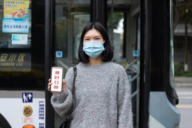 戴口罩女孩手拿着提示语，戴好口罩