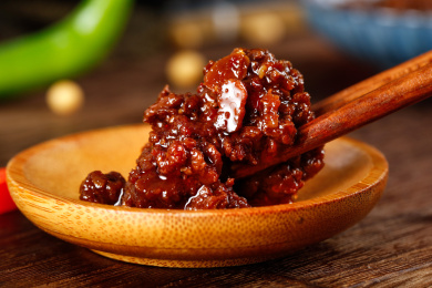 深底上盘子里放着豆豉牛肉酱和筷子上夹着酱