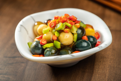 棕色木纹桌上放着一盘巧拌小皮蛋   