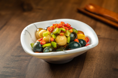 棕色木纹桌上放着一盘巧拌小皮蛋   