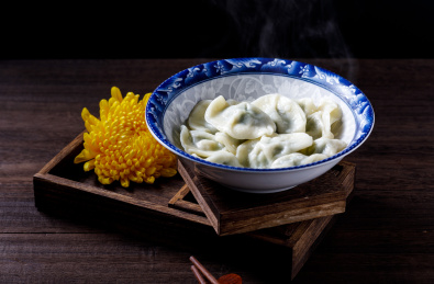 棕色木桌上一碗热气腾腾的中国传统食物饺子