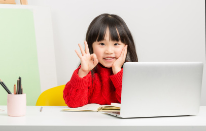 在室内上网络培训课小女孩伸出ok的手势