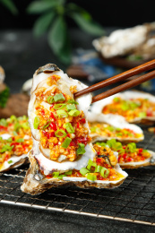 筷子上夹着一个蒜蓉烤生蚝