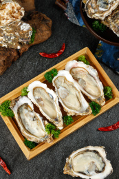 黑底上放着一盘撬开的生蚝