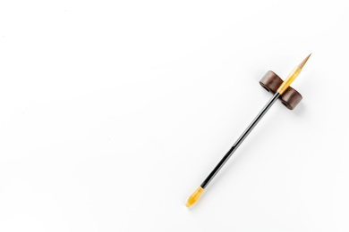 一支架在笔架上的毛笔特写白色背景