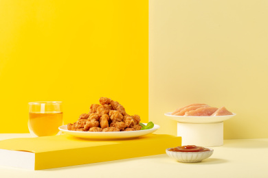 纯色背景上满满一盘油炸鸡米花