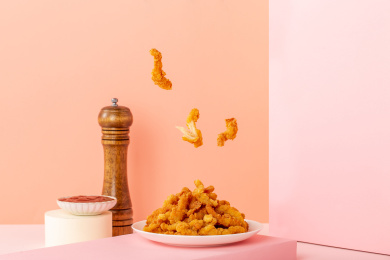 纯色背景上满满一盘油炸鸡柳