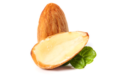 白底上放着一颗巴旦木和半边坚果仁