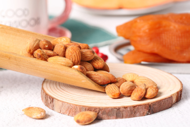 木底上放着巴旦木和竹勺里挖着扁桃仁