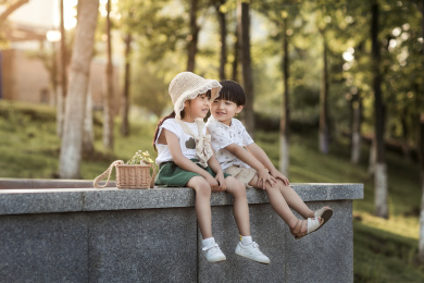 姐弟坐在公园里有说有笑