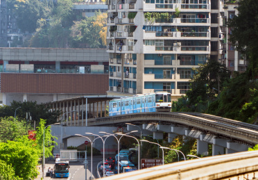 中国重庆市区高楼下的轻轨列车