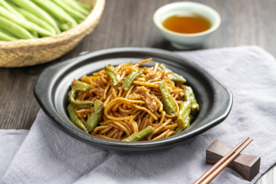 扁豆焖面摆放在木桌面上