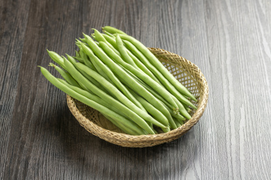 一簸箕四季豆豆角摆放在木桌面上
