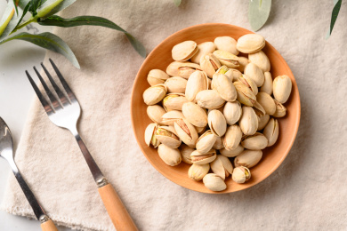 桌面上的木纹盘子里面的香脆的开心果