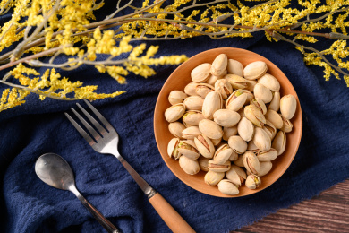 桌面上的木纹盘子里面的香脆的开心果