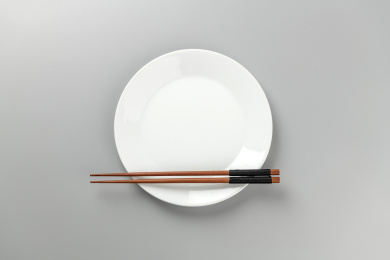 光盘行动空盘子筷子特写灰色背景