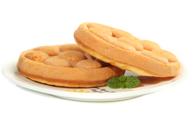 白底盘子里放着两块完整的港式鸡蛋仔蛋糕