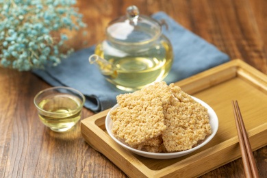 一盘锅巴摆放在木桌面上特写