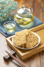 一盘锅巴摆放在木桌面上特写