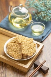 一盘锅巴摆放在木桌面上特写