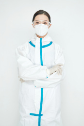 穿白色防护服佩戴护目镜口罩的女性医疗人员