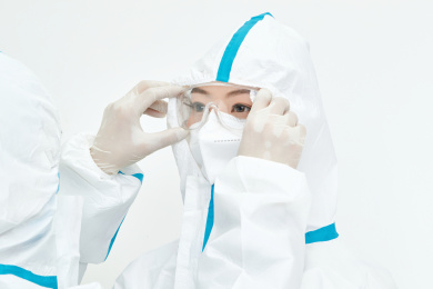 穿白色防护服佩戴护目镜口罩的女性医疗人员