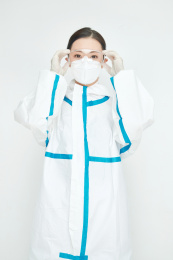 穿白色防护服佩戴护目镜口罩的女性医疗人员
