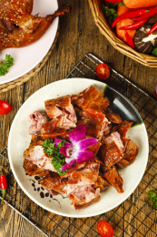 烧烤网上放着一盘切块的香酥鸭