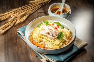 棕色木纹桌上放着一盘鸡丝凉面