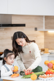 年轻妈妈和女儿在厨房准备食材