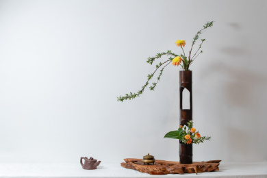 浅色背景深色花瓶上一束盛开花朵的插花装饰