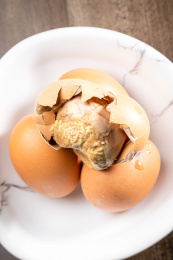 棕色木纹桌上放着一盘毛蛋